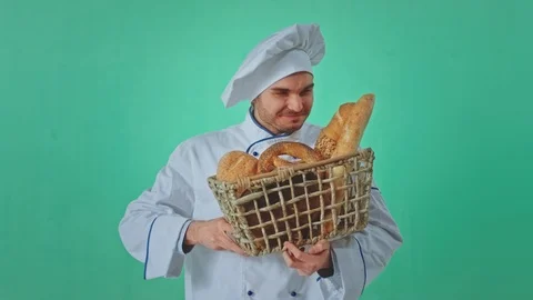 Inside of a green studio smiling large baker with a basket of fresh bread Stock Footage 125488480