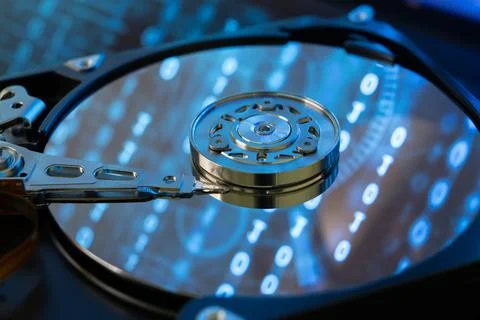 Inside of a hard disk HDD with binary code, zeros and ones, projected onto th Stock Photos