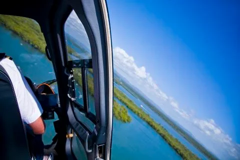 Inside helicopter in air without door looking at scenery Stock Photos
