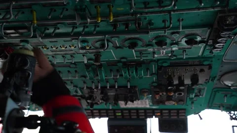 Inside helicopter cabin. Fingers switch toggle switches on top panel of Stock Footage 218586776