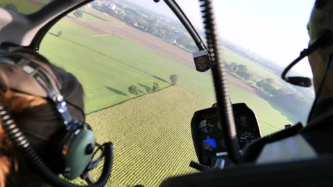 Inside helicopter cockpit during turn over green fields Stock-Footage 219774922