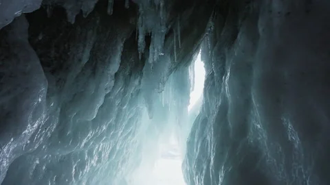 Inside ice cave. Sunlight enters through crevice, illuminates sleek frozen walls Stock Footage 166565903