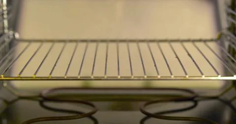 Inside a kitchen oven with metal rack and heating element visible during Stock Photos