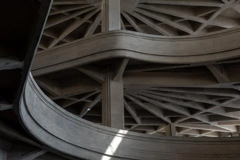 Inside a large circular concrete structure with curved ramps and intricate beams Stock Photos