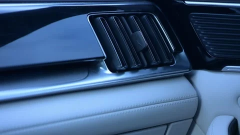 Inside a luxurious car, soft beige leather contrasts with glossy black accents Stock Footage 335193575