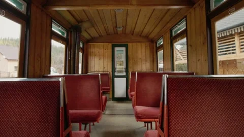 Inside a Mocanita train carriage with red seats and wooden panels Stock Footage 346717990