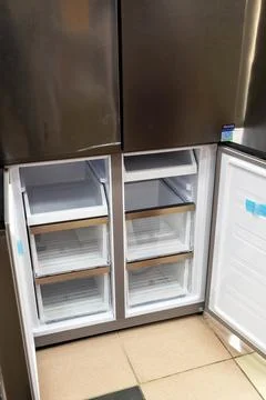 The inside of a modern refrigerator shows empty shelves and drawers Stock Photos
