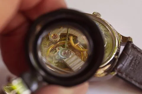 Inside og watch seen through magnifying glass at watchmaker. Close-up Stock Photos