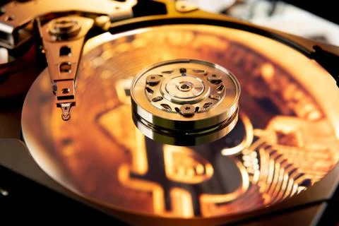 Inside of an open computer hard drive with the projected bitcoin symbol Stock Photos