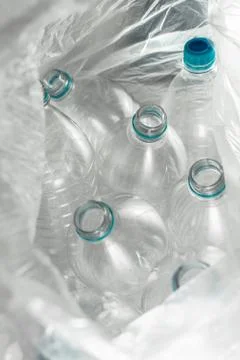 Inside an open transparent plastic bag with several empty bottles of liter an Foto stock