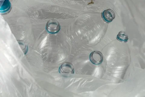 Inside an open transparent plastic bag with several empty bottles of liter an Foto stock
