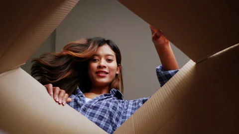 Inside of package view, slow motion shot, Happy young woman opens package and Stock-Footage 198480176