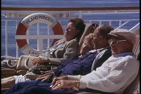 INSIDE PASSAGE, ALASKA, 1989, Crowd in deckchairs, bundled up on deck Stock Footage 12146503