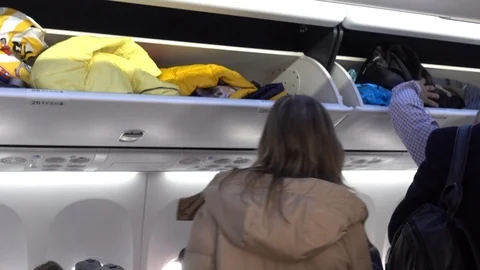 Inside the plane, shelves for suitcases. The point of view of the passenger w Stock Footage 87913310