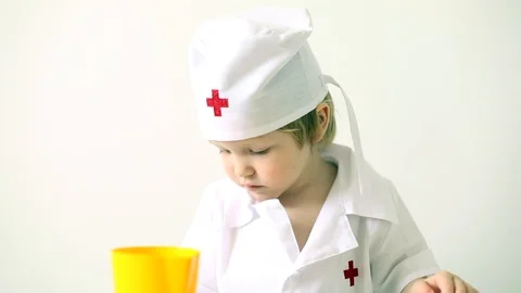 Inside portrait of little thoughtful boy playing doctor in white uniform hat Stock Footage 129092742