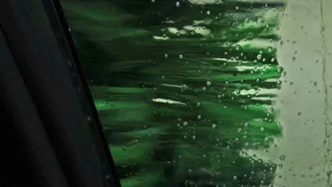 Inside a relentless car wash with fast rotating brushes and running water Stock Footage 173477090