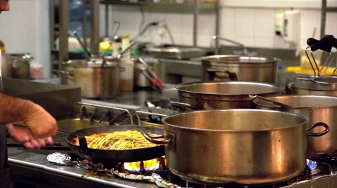 Inside restaurant kitchen chefs assistants prepare dish in the frying pan Stock Footage 47860992