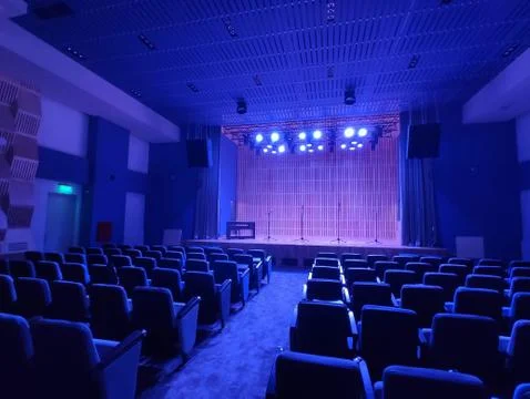 Inside shot of a small empty auditorium with four microphones on the stage Foto stock