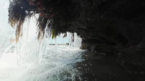Inside of a small natural waterfall covered in green moss created by a Stock Footage 242081445