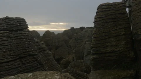 Inside the stone strata over the ocean at sunset, in New Zealand Stock Footage 219915369