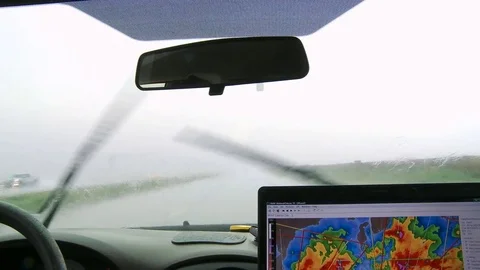 Inside a storm chaser's van on a rainy road, close view of weather map with hot Stock Footage