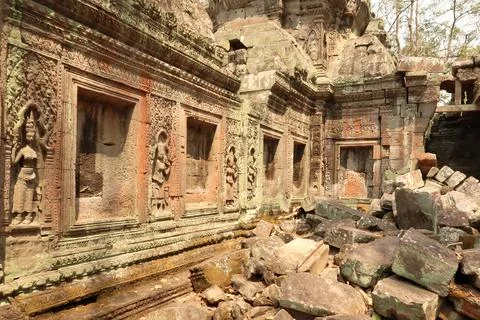 Inside the Ta Prohm Temple, apsaras are carved into a wall covered with red.. Stock Photos