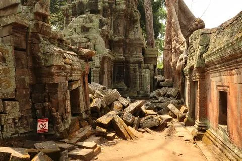 Inside the Ta Prohm Temple, small buildings are overgrown with red, green mos Stock Photos