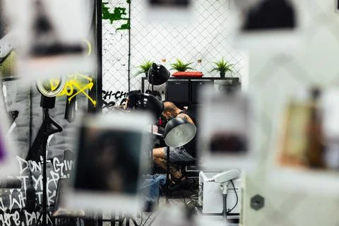 Inside the tattoo studio. The master at work creates a tattoo on the client's Stock Photos