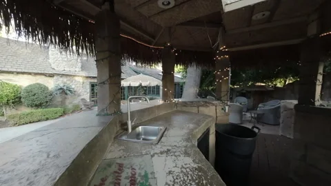 Inside a thatched outdoor bar with string lights and sink Stock Footage 345567907