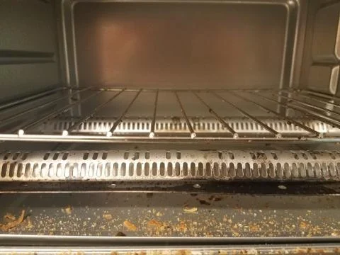 Inside a toaster oven with bread crumbs Stock Photos