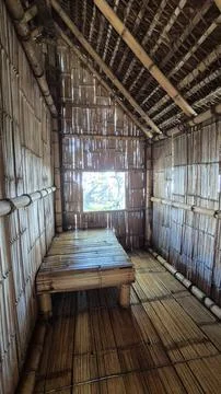 Inside a traditional bamboo hut with a rustic bamboo bed. 库存照片