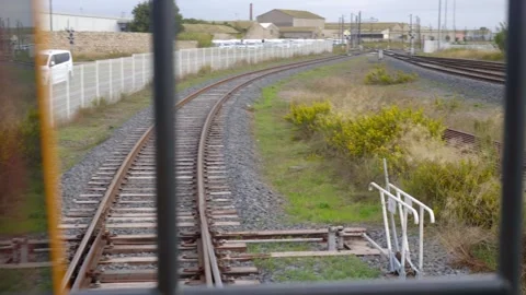 Inside a train cabin looking out over railway tracks and switches at a busy Stock Footage 337976125