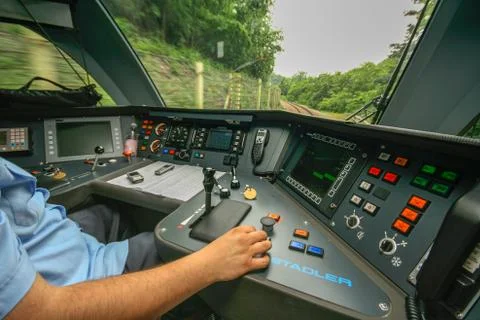 Inside the train cabin with a train driver in operation while driving Stock Photos