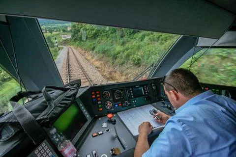 Inside the train cabin with a train driver in operation while driving Stock Photos