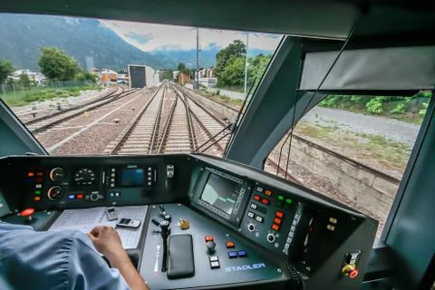 Inside the train cabin with a train driver in operation while driving Stock Photos
