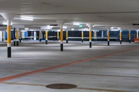 Inside underground large empty parking lot with barrier entrance at night ill Stock Photos
