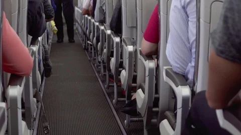 Inside view of airplane aisle during flight. Passengers in their seats, cabin Stock Footage 82833065