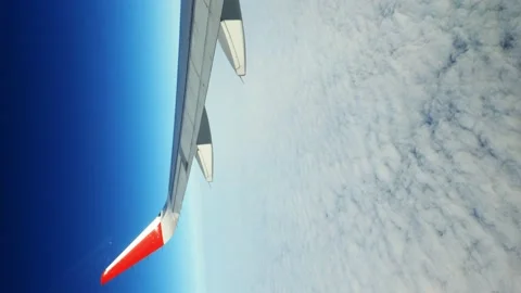 Inside view of the airplane window, looking at the airplane wing and clouds. Stock Footage 167647545