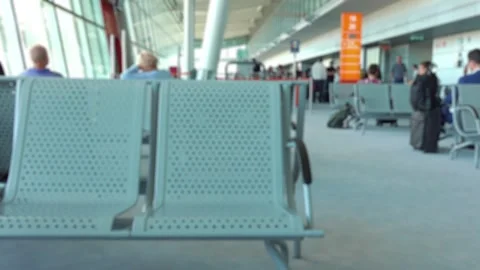 Inside view of an airport terminal with empty seats and people in the backg.. Stock Footage 282472913