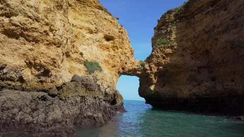 Inside view from cliff formation on stone arc from ocean Video stock 273673951