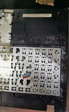 An inside view of a disassembled black laptop casing showing the metal keyboard Stock Photos