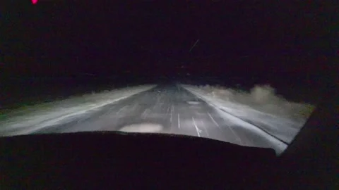 Inside view of front windshield of a driving in blizzard car. Empty night road. Stock Footage 144465857