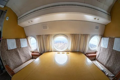 Inside view of a large passenger jet at altitude, showing windows revealing l Stock Photos