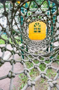 Inside view of a long rope mesh pipe, at the end of the tunnel yellow playgro Stock Photos