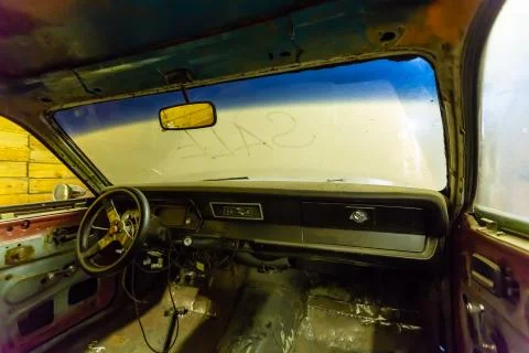 Inside view of old broken car interior with dusty vehicle dashboard, back mirror Stock Photos