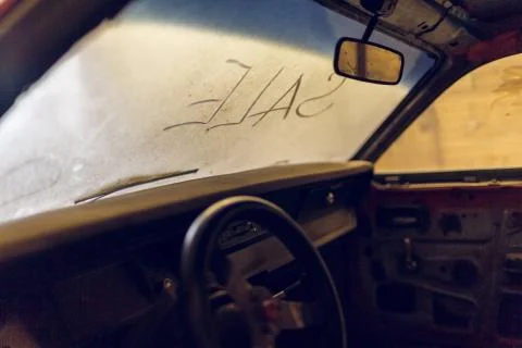 Inside view of old broken car interior with dusty vehicle dashboard, back mirror Stock Photos