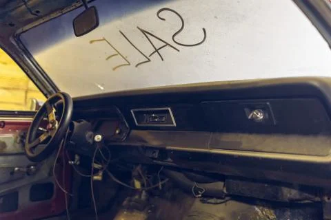 Inside view of old broken car interior with dusty vehicle dashboard, back mirror Stock Photos