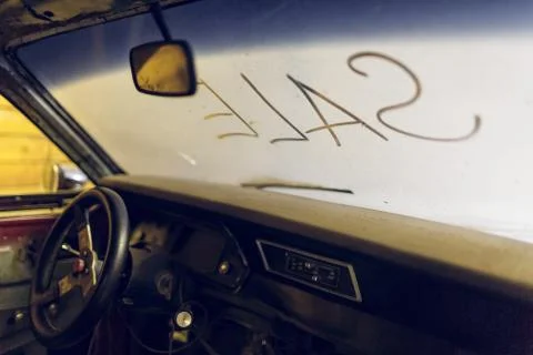Inside view of old broken car interior with dusty vehicle dashboard, back mirror Stock Photos