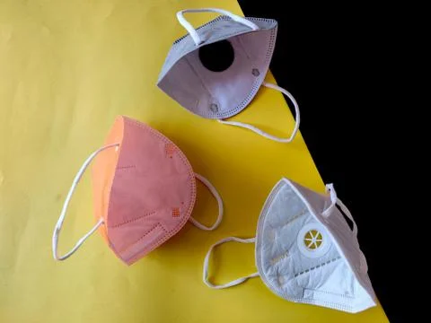 Inside view of three KN-95 face masks in white,grey and orange color. Isolate Stock Photos