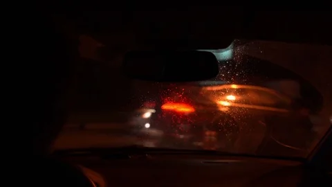Inside view on a wet windshield. Focus on the glass. Blurred reflections. Stock Footage 107999634